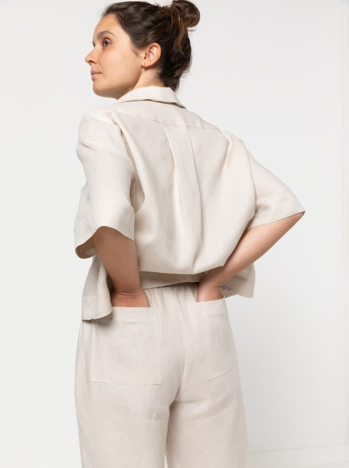 model wearing Albie Woven Pant and Short sewing pattern, highlighting elastic waist, straight wide leg, and optional pockets in front and back views.