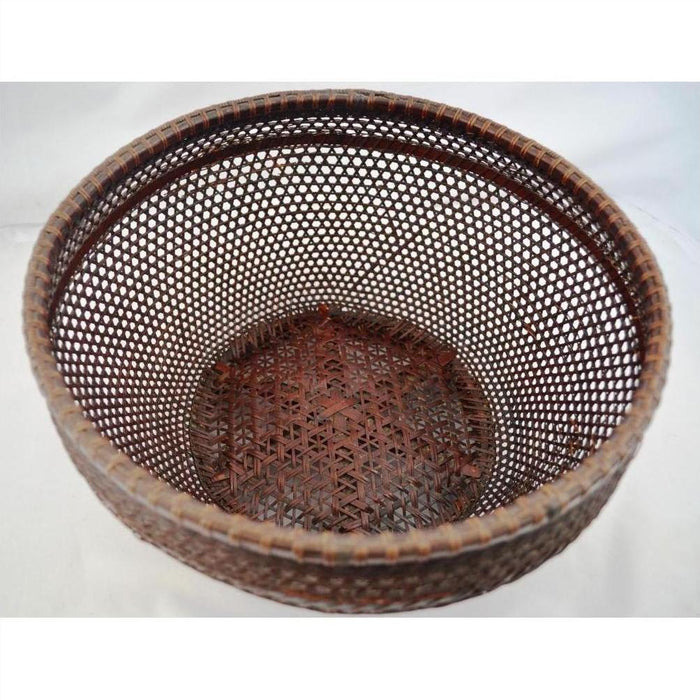 Brown rattan Chinese storage basket with open mesh sides and intricate solid base, top view.