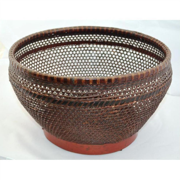 Brown woven rattan round storage basket with open lattice design, displayed on a white background.