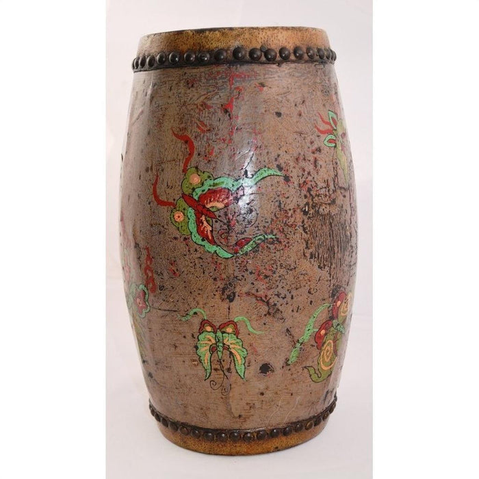 Brown wood and leather drum with hand painted floral designs and metal studs on top and bottom edges, close-up.