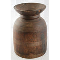 Close-up of brown wooden antique Indian milk storage container with etched lines and wide flared opening.