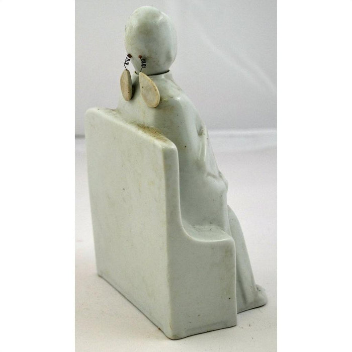 White porcelain Blanc de Chine seated doll with oval earrings on a block base, rear view.