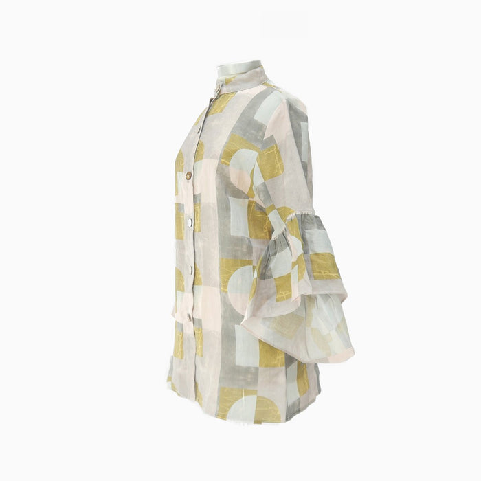 A high neck linen blouse with bell ruffle sleeves, featuring a color blocked geometric pattern in shades of pink, gray, aqua, and blush, with buttons made from smoothed raw coconut shells.