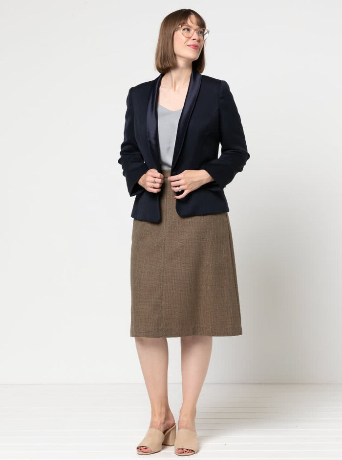 Woman wearing a navy blazer made using the Bronnie Tuxedo Jacket Sewing pattern  and brown skirt against a white background
