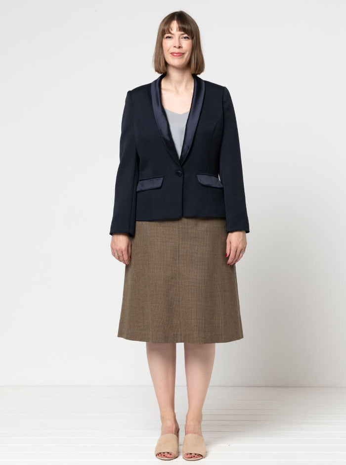 Woman wearing a navy blazer made using the Bronnie Tuxedo Jacket Sewing pattern  and brown skirt on a white background