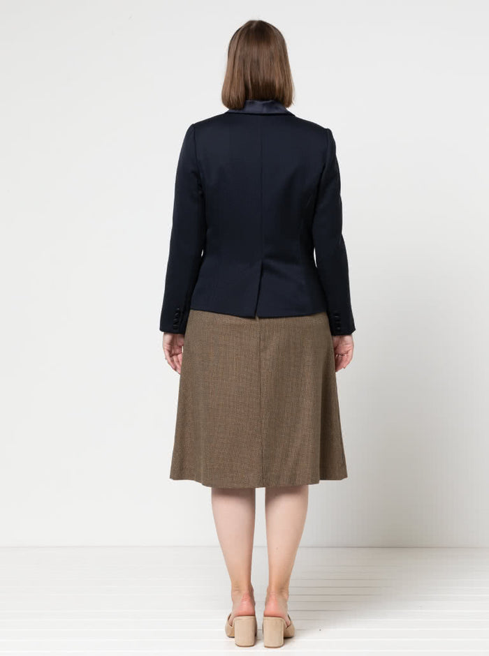 Person wearing a navy blazer made using the Bronnie Tuxedo Jacket Sewing pattern  and brown skirt on a white background