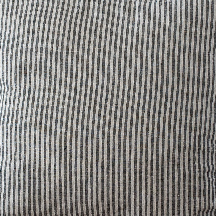Striped pillow on a wooden chair against a plain wall