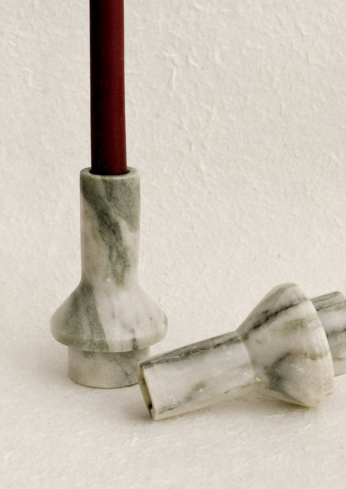 A sculptural candle holder in variegated green marble.