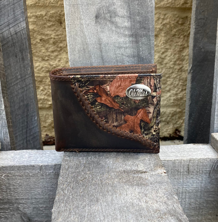 Zep-Pro University of Mississippi 1/2 Mossy Oak Camo/Brown Leather Bi-fold Wallet. Front view features:
Crazy Horse Brown Distressed Leather
Mossy Oak Break-Up Leather Print Design
Laced “Fence-row” Border between camo and brown leather
Ole Miss silver tone concho on upper right corner on camo