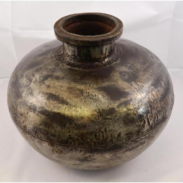 Close-up of a round, tarnished metal Indian water jug with wide neck on a plain background.