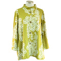A green jacket with white geometric pattern embroidery, displayed on a mannequin.