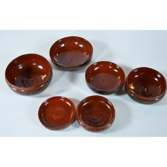 Close-up of three hand-lacquered jewelry boxes with six round brown ceramic bowls on a white surface.