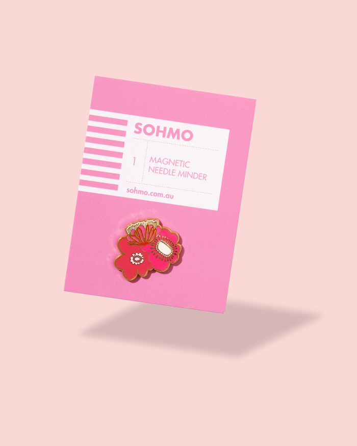 Pink magnetic needle minder with floral design on a pink background