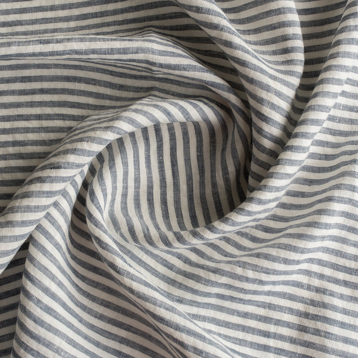 Close-up of Marine Stripe 100% Linen Fabric with alternating dark and light stripes.