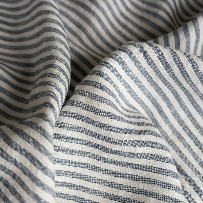 Close-up of Marine Stripe 100% Linen Fabric with blue and white horizontal lines.