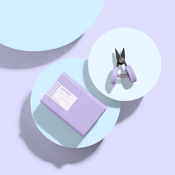 Purple nail clipper set on a light purple background