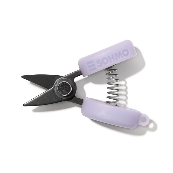 Small pair of scissors with purple handles on a white background