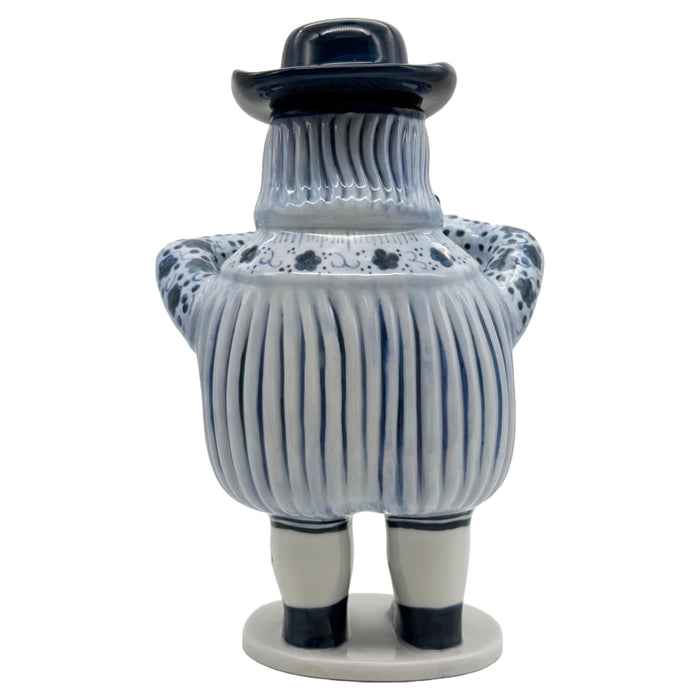 A ceramic figurine of a European-inspired character with a removable hat, dressed in blue and white striped attire, holding a cup.