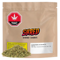 Front view of a tan resealable pouch labeled "OG Rootbeer" with a colorful SHRED logo, THC warning icon, and a small pile of loose dried herb at the base.