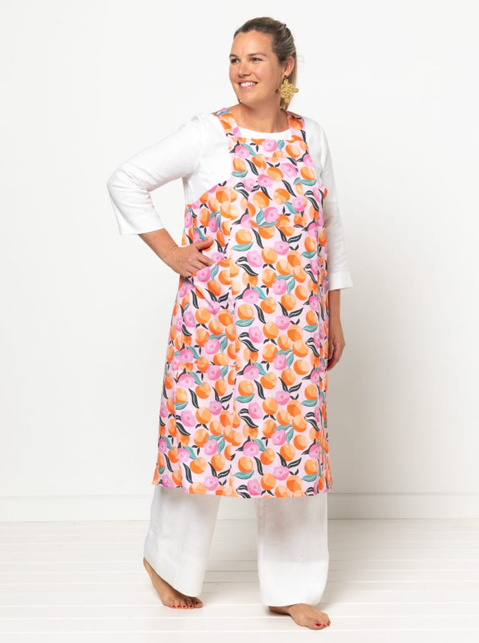 front view of Pinnie Cross-Back Cooking Apron sewing pattern featuring knee-length design, angled or patch pockets, and sturdy fabric options for versatile use.