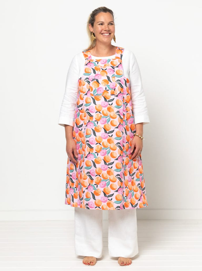front view of Pinnie Cross-Back Cooking Apron sewing pattern featuring knee-length design, angled or patch pockets, and sturdy fabric options for versatile use.