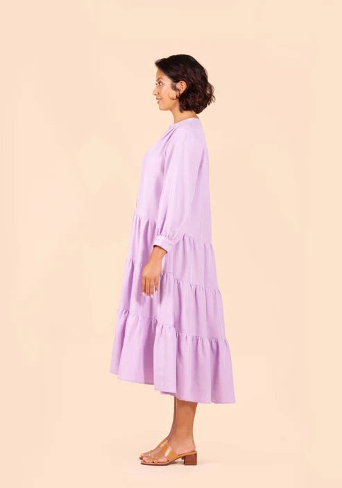 Woman wearing a light purple Poppy Dress against a beige background