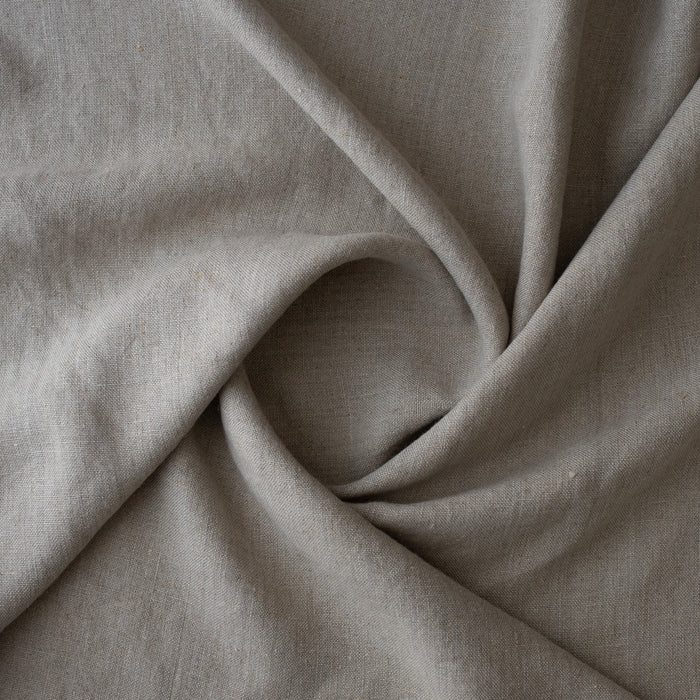 A close-up of drapedRaw Trace Extra Wide Heavy Linen Fabric Australia with a soft, textured weave, arranged in elegant folds.