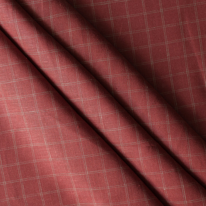 Close-up of Red Sand Check linen fabric in earthy brick red with teal twin pinstripes, 100% linen, 130 GSM, 60 LEA with a diagonal fold