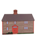 A wooden block replica of the Samuel Pickman House in Salem, Massachusetts, featuring the front view of the house with a red door and gray siding.