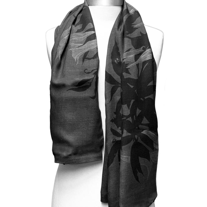 A scarf with a floral pattern in shades of gray and black.