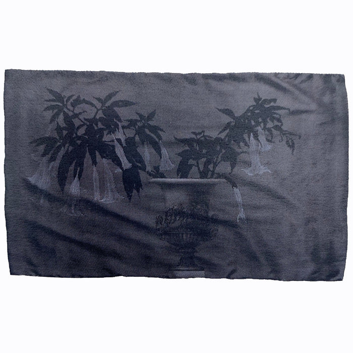 A scarf with a floral pattern in shades of gray and black.