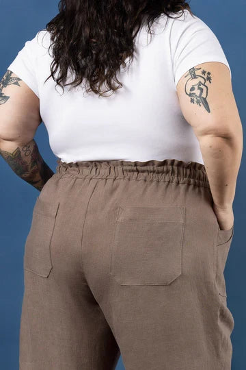 Person wearing a white t-shirt and brown pants made using Sepia Pants and Shorts sewing pattern  against a blue background