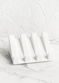 A slanted soap dish made in white concrete.