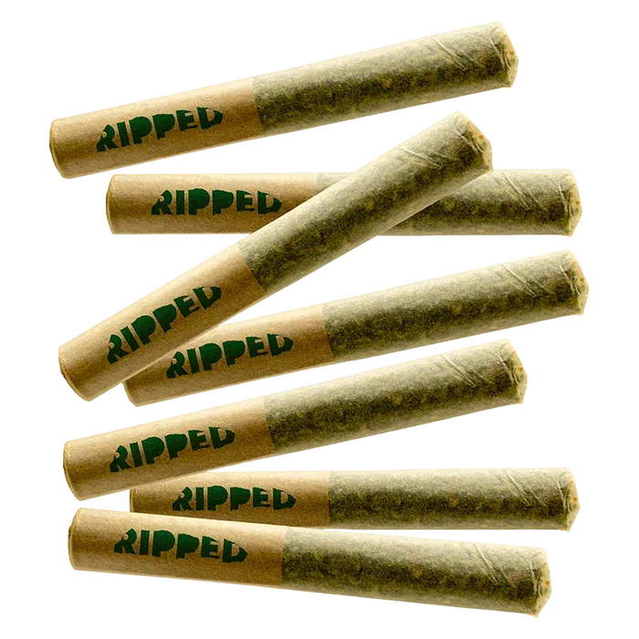 Angled top-down view of seven rolled joints labeled "Sour x Papaya PR 7 x 0.5 g" with brown paper tips printed "RIPPED" against a white background