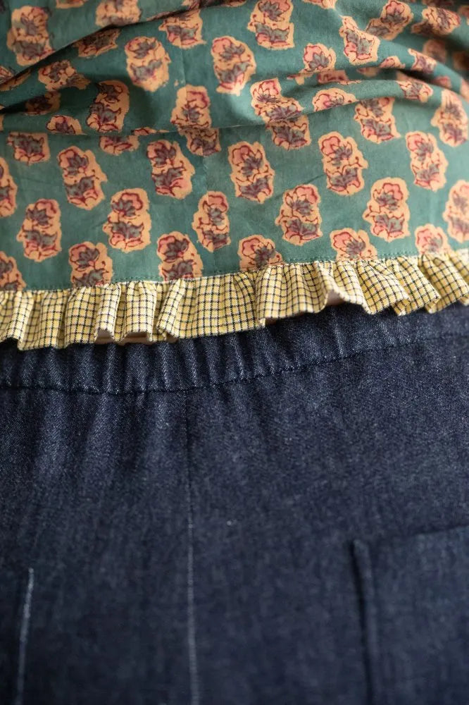 Close-up of a fabric with floral pattern and ruffled edge on a dark background