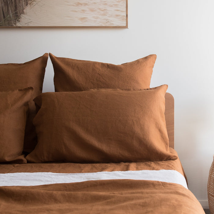 Tobacco Brown bedding set on a bed with a neutral wall and framed picture in the background