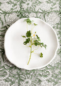 A round white concrete tray with ruffled, wavy edges.