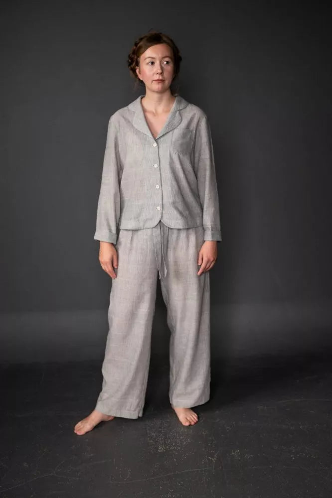 Person wearing a gray winnie pajama set against a dark background