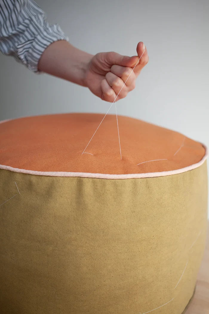 Eco-friendly Zero Waste Pouffes in mustard yellow and light grey, with textured fabric and pink stitching, embodying sustainable home decor